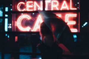A man standing in front of a neon sign