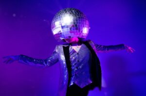 A person wears a disco ball on their head.
