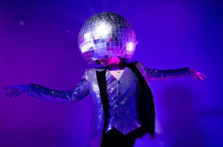 A person wears a disco ball on their head.